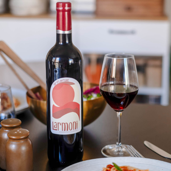 Larmoni Rouge IGP Atlantique avec assiette de pâtes à la tomate sur une table de restaurant