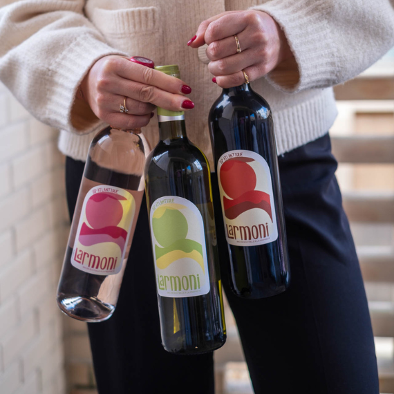 Personne tenant les bouteilles Larmoni IGP Atlantique – Rouge, Rosé, Blanc Sec et Blanc Moelleux