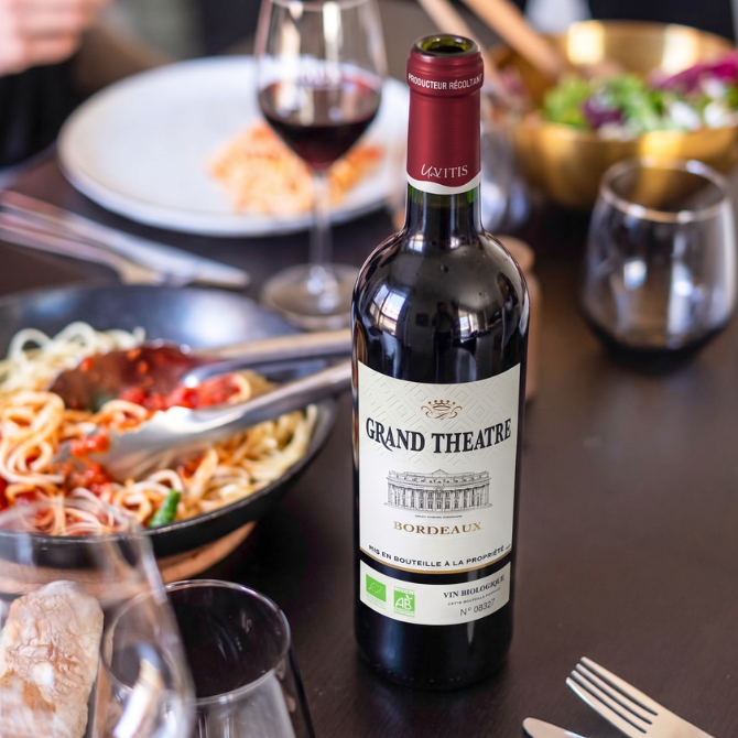 outeille de vin rouge bio Grand Théâtre ouverte accompagnée d’un plat de pâtes à la sauce tomate