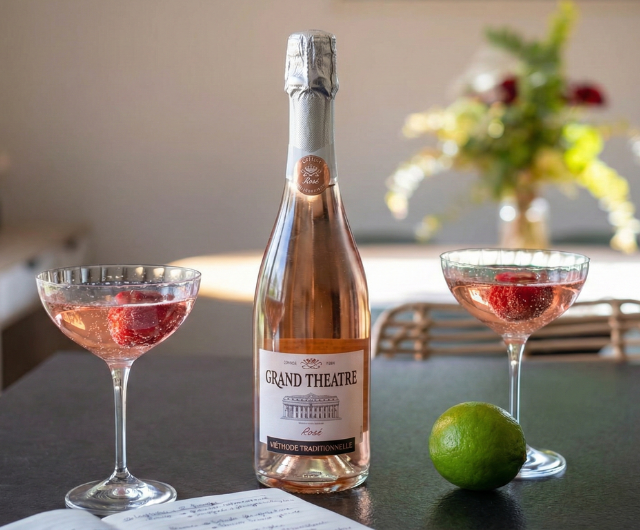 Bouteille de crémant rosé avec cocktail pétillant rose, framboises et c