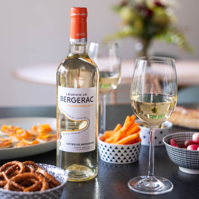 Légende de Bergerac Moelleux AOP Bergerac sur table d’apéritif avec blinis à la truite fumée et légumes croquants