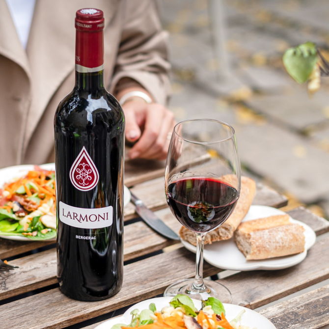 Larmoni AOP Bergerac Rouge sur table de repas avec verres et assiettes