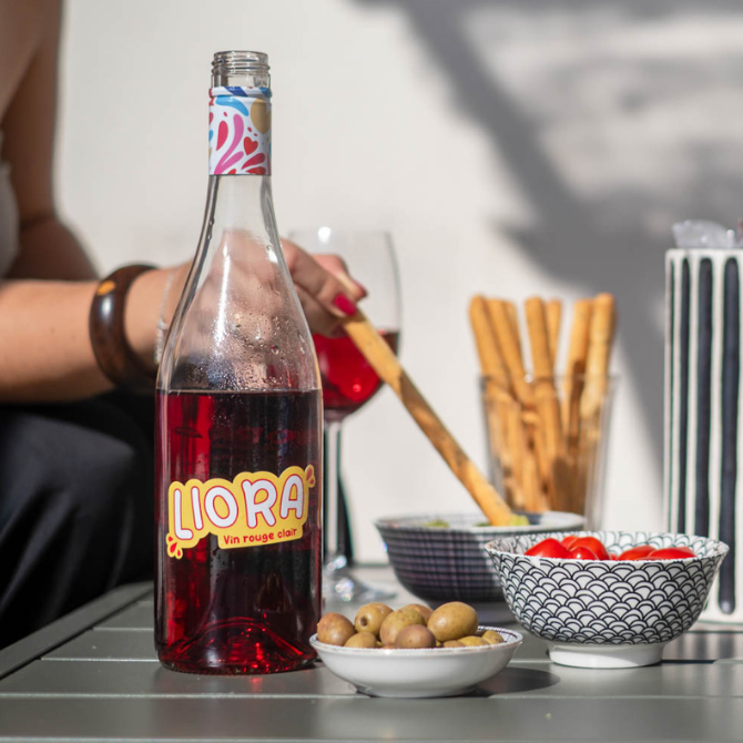 Bouteille de Liora vin rouge clair sur table d’apéritif d’été entre ami