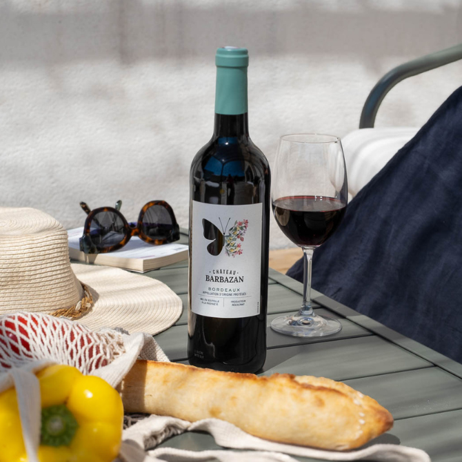 Château Barbazan AOP Bordeaux Rouge Bio sur table extérieure avec panier de légumes et baguette