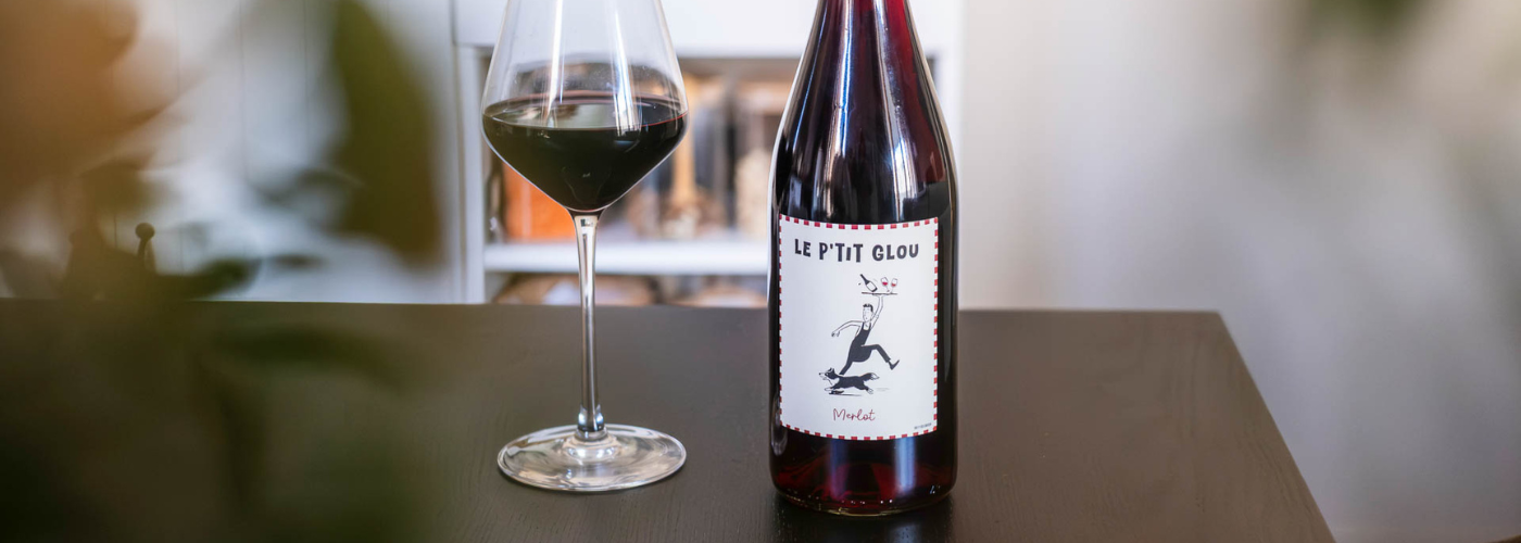 Bouteille Le P’tit Glou Rouge 100 % Merlot sur un comptoir de restaurant